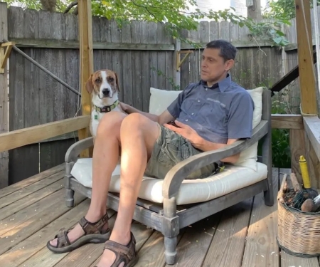 Chris Dart on a deck with his dog Watson