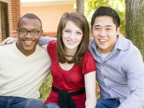 Three diverse friends in a group smiling