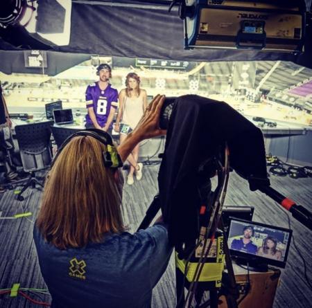 Lynn Winter operating a tv camera at a Minnesota Vikings game